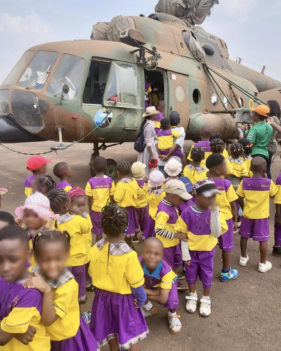 Groupe d'élèves de La Casa Del Chico devant un hélicoptère militaire