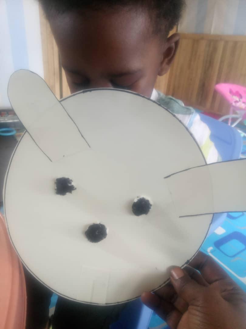 Enfant tenant un masque de lapin fabriqué lors d'un atelier créatif à la crèche