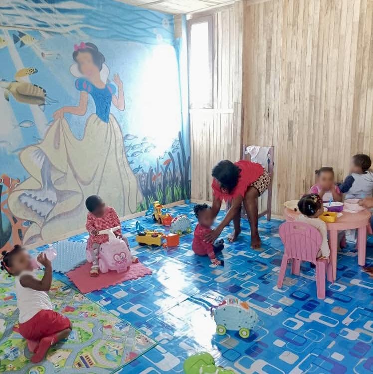 Bébés jouant dans la salle de la crèche avec fresque Blanche-Neige