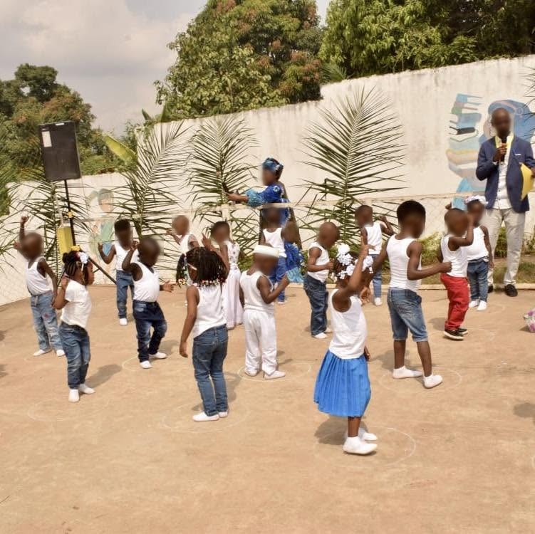 Enfants dansant en cercle dans la cour de récréation de La Casa Del Chico